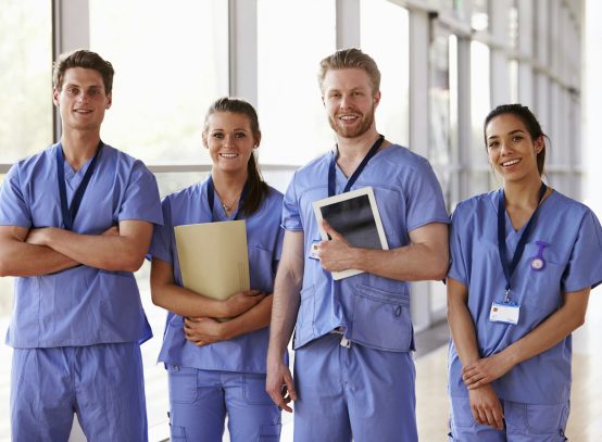 Group portrait of healthcare workers in hospital corridor